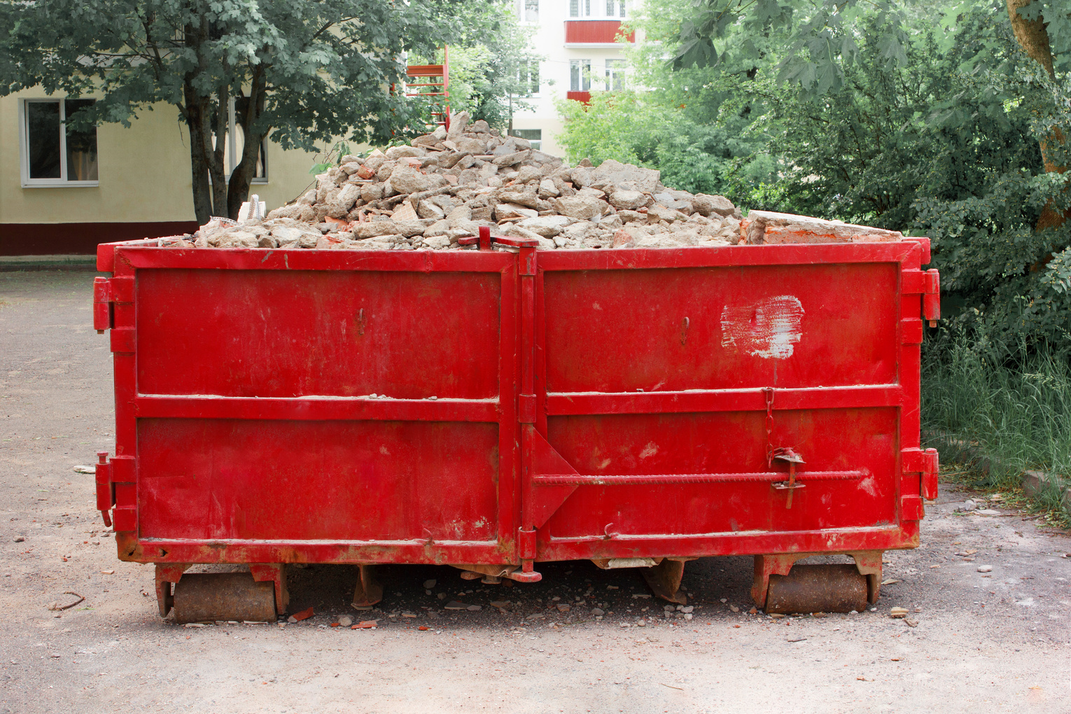 Red container with solid domestic and construction waste. Ca